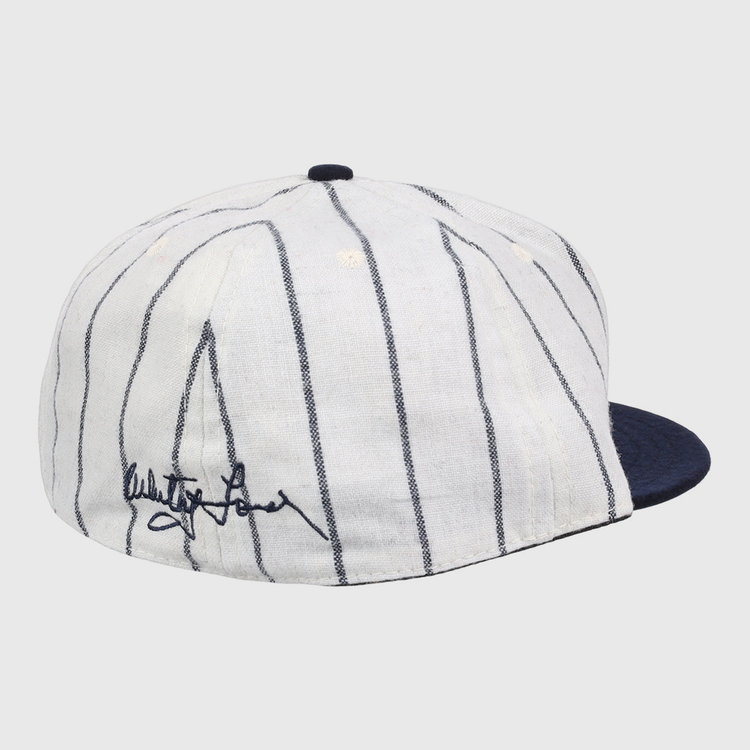 The Ebbets Field Flannels Whitey Ford Signature Series Ballcap features vintage wool, thin navy pinstripes, a solid navy brim, and a black autograph on the side inspired by Whitey Ford’s iconic cap style.