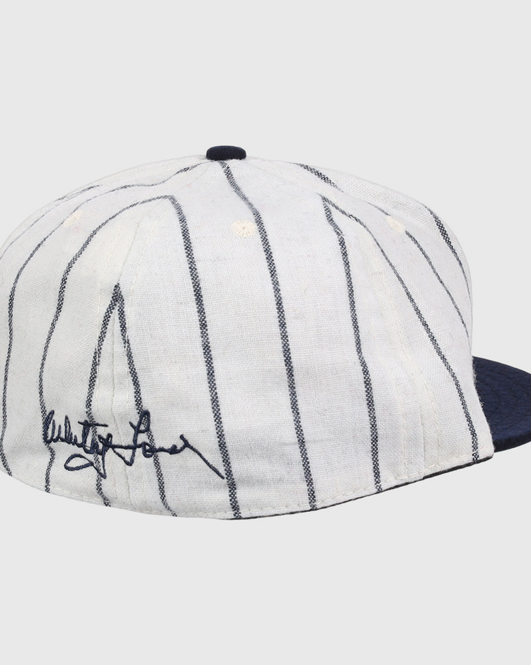 The Ebbets Field Flannels Whitey Ford Signature Series Ballcap features vintage wool, thin navy pinstripes, a solid navy brim, and a black autograph on the side inspired by Whitey Ford’s iconic cap style.