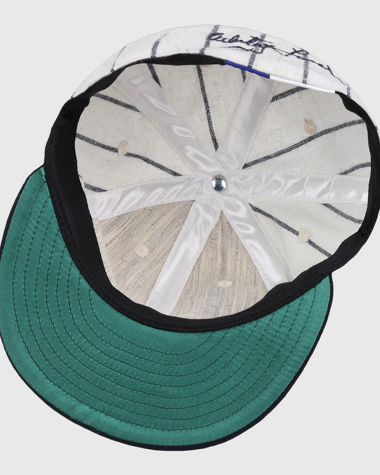 The underside of the Ebbets Field Flannels Whitey Ford Signature Series Ballcap features a green brim, white interior with black pinstripes, silver top button, and visible stitching—hallmarks of authentic vintage Yankees style.