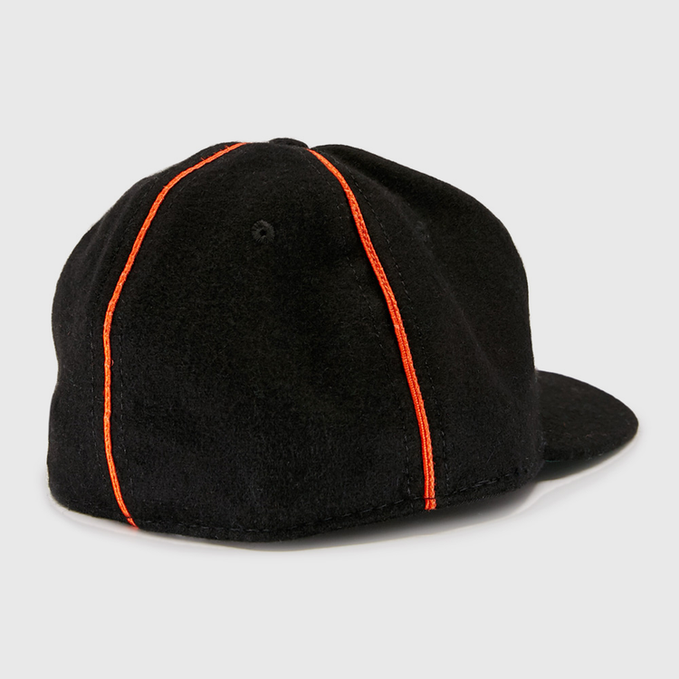 The EFF Wichita Monrovians 1925 Vintage Ballcap, inspired by classic Negro Leagues designs, features two vertical orange stripes running from the top button to the brim as seen from the back.