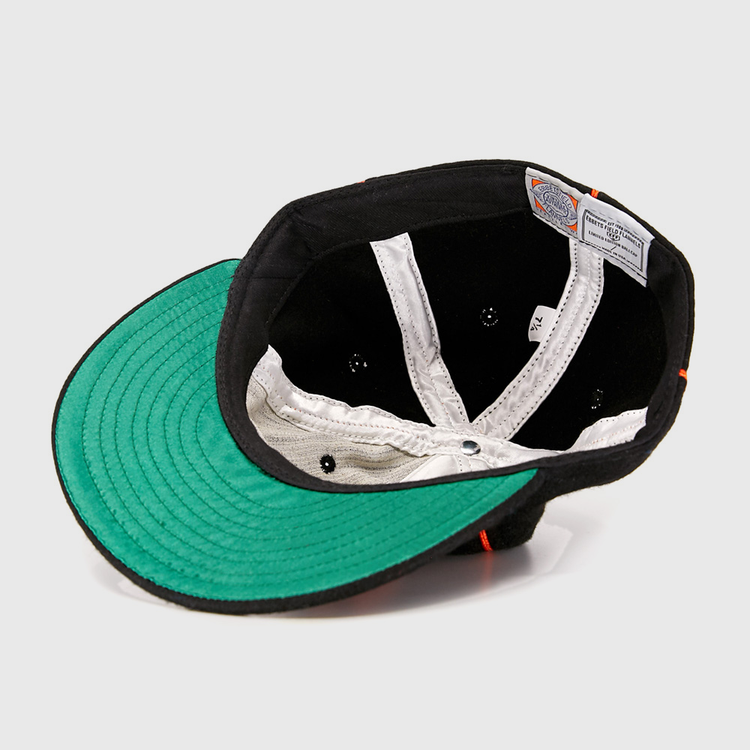 Turned inside out, the Wichita Monrovians 1925 Vintage Ballcap by EFF reveals a black sweatband, white inner lining, green underside of the brim, and sewn-in labels—showcasing vintage style inspired by classic Negro Leagues caps.