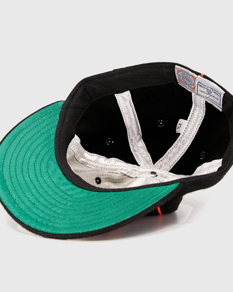 Turned inside out, the Wichita Monrovians 1925 Vintage Ballcap by EFF reveals a black sweatband, white inner lining, green underside of the brim, and sewn-in labels—showcasing vintage style inspired by classic Negro Leagues caps.