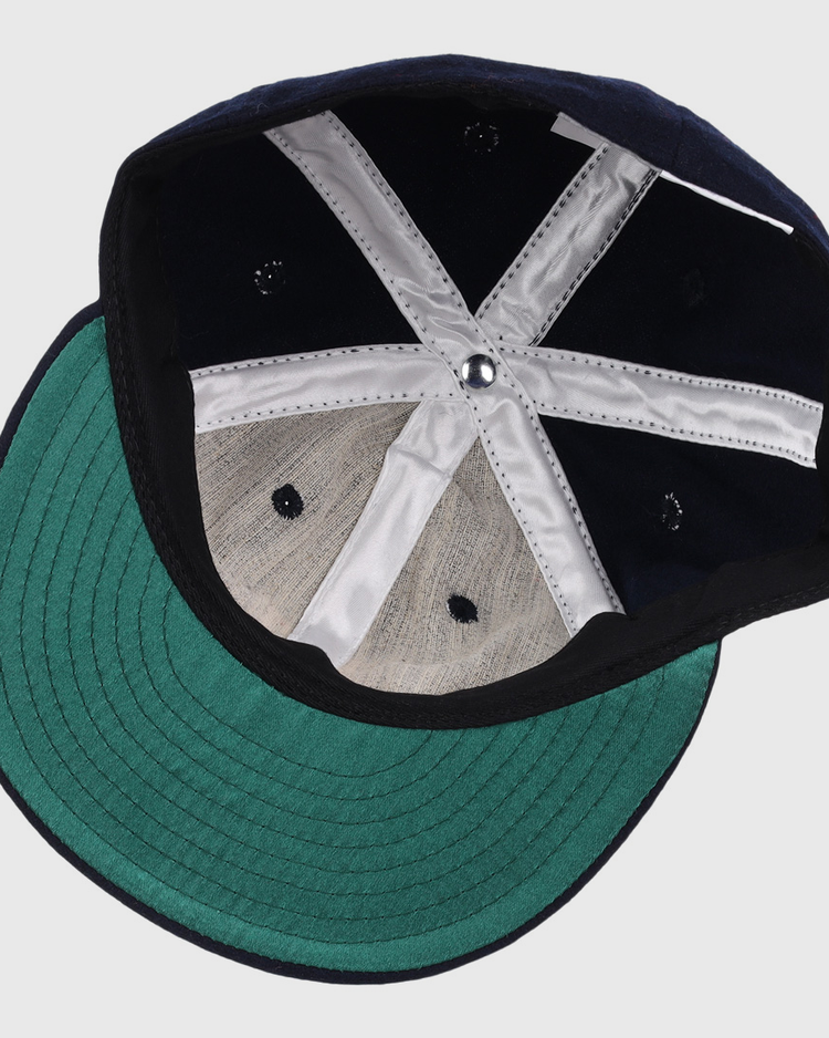 The image shows the inside of an EFF Winston-Salem Red Sox 1966 Vintage Ballcap, featuring a green brim and white stitching. The cap is upside down, displaying its structure and fabric panels.