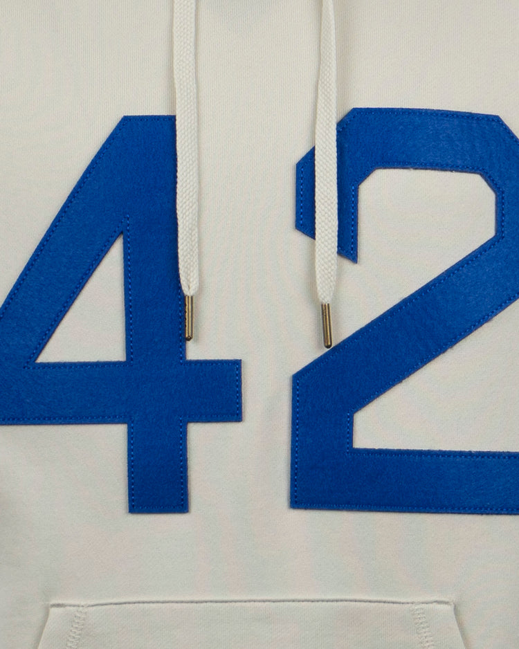A close-up of the EFF Jackie Robinson French Terry Script Hooded Sweatshirt in natural—a hoodie with bold blue 42 on the front and white drawstrings, honoring the 75th anniversary.