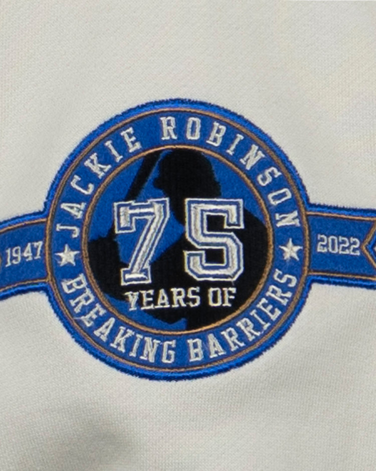 The EFF Jackie Robinson French Terry Script Hooded Sweatshirt - Natural features a circular patch with 75 Years of Breaking Barriers, the years 1947 and 2022, a blue number 75, and a baseball player silhouette—a perfect tribute to the anniversary.