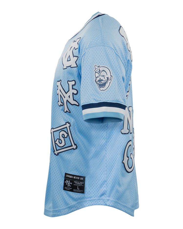 The EFF Negro League Allover Vintage Inspired NL Replica V-Neck Mesh Jersey in light blue features white and navy patches, including letters and a cartoon face, plus a black label at the bottom hem.