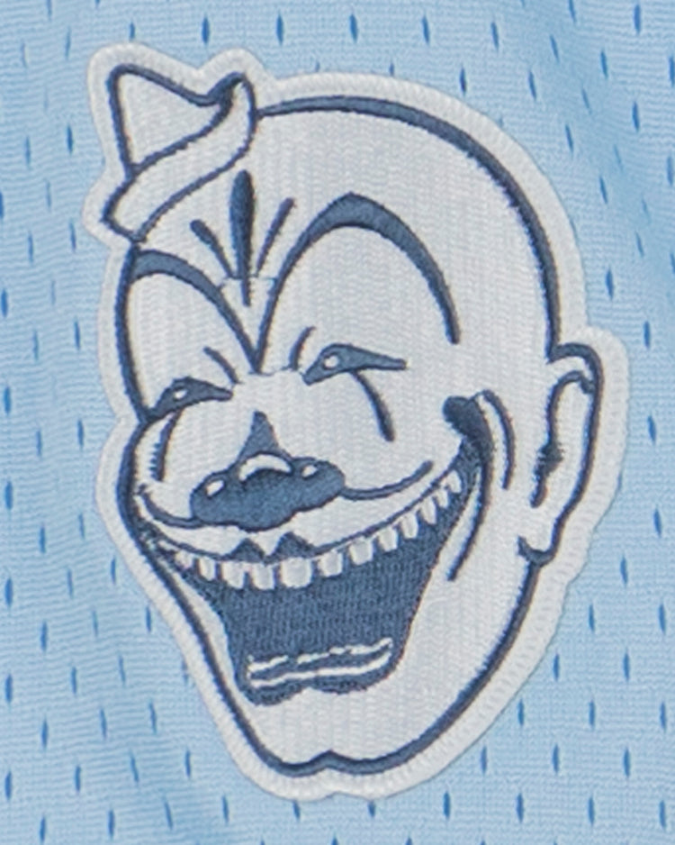 An embroidered cartoon clown face with bold features decorates this EFF Negro League Allover Vintage Inspired NL Replica V-Neck Mesh Jersey in light blue, echoing the spirited designs of classic Negro Leagues Baseball uniforms.