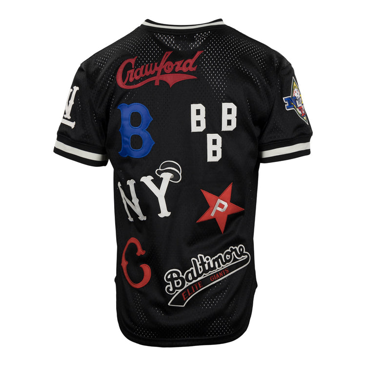 The EFF Negro League Allover Vintage Inspired NL Replica V-Neck Mesh Jersey in black features white trim and colorful team patches, celebrating historic Negro League Baseball teams, all crafted in classic Ebbets Field Flannels style.