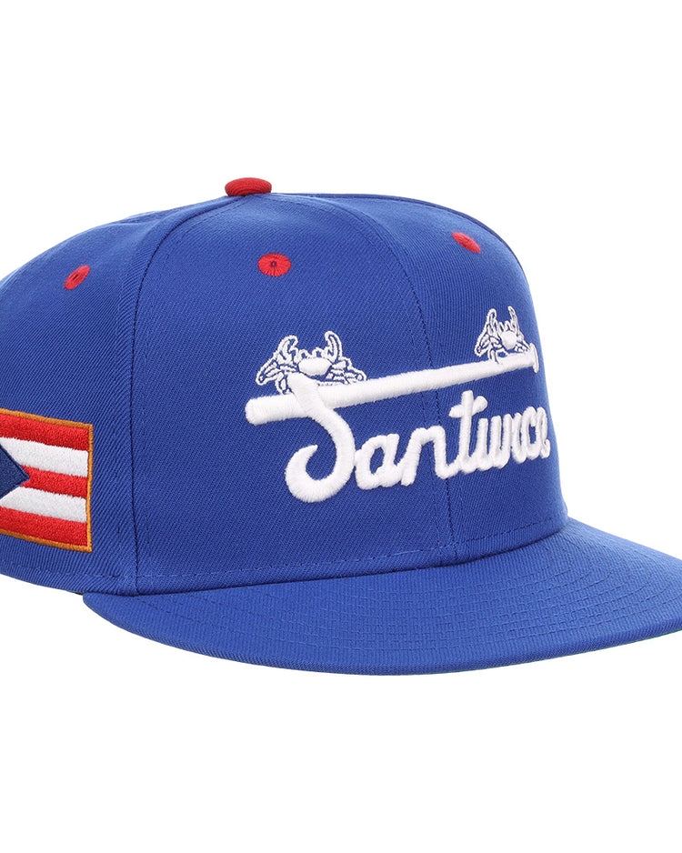 The EFF Santurce Cangrejeros NLB Flip Fitted Ballcap is a blue cap featuring Santurce with a bat and crab, a Puerto Rican flag patch, and honors Puerto Rican League legends like Roberto Clemente.