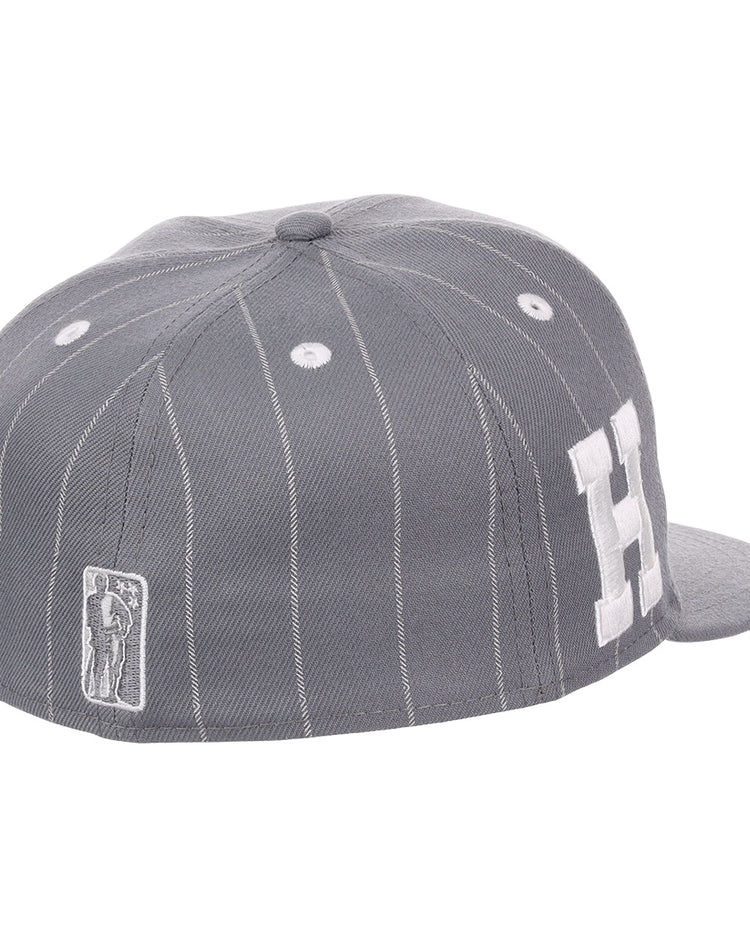 The EFF Homestead Grays NLB Black Pinstripe Fitted Ballcap features black pinstripes, white stitching, a large white H on the side, and a small embroidered batter logo near the back, inspired by the Negro National League team.