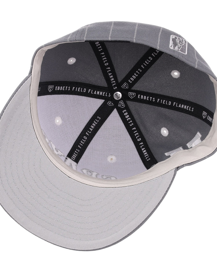 A top view of the EFF Homestead Grays NLB Black Pinstripe Fitted Ballcap, showing black and white “EBBETS FIELD FLANNELS” seams, white ventilation holes, and a light grey underside on this vintage Negro National League cap.