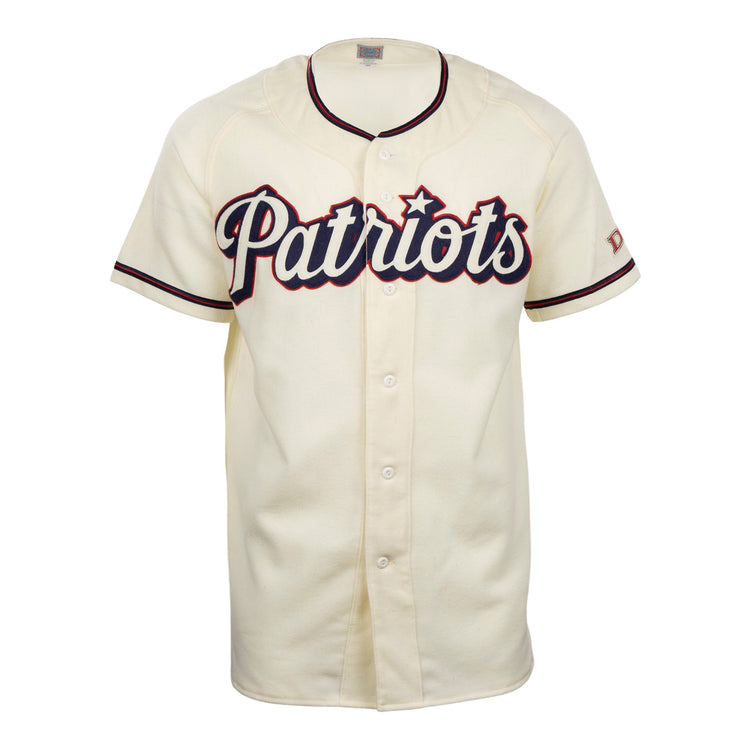 The EFF Dallas Baptist University Home Jersey is cream-colored with black and red trim, Patriots in large script on the chest, a flannel-style design, front buttons, and short sleeves.