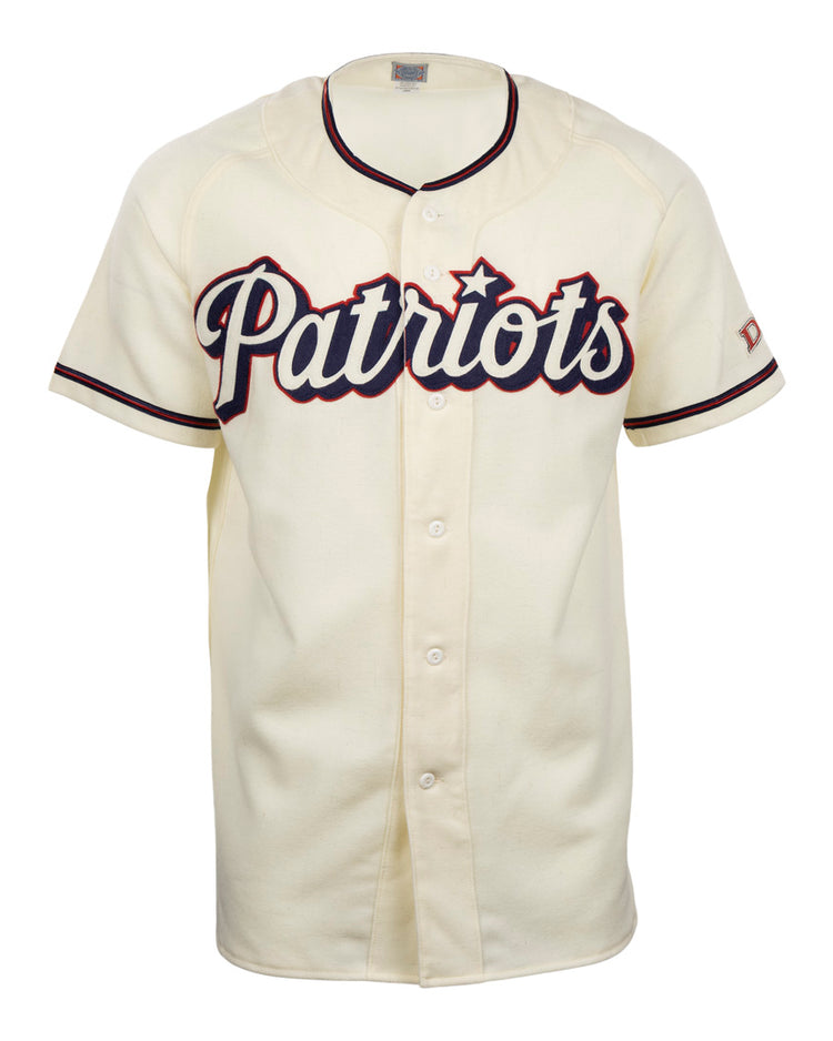 The EFF Dallas Baptist University Home Jersey is cream-colored with black and red trim, Patriots in large script on the chest, a flannel-style design, front buttons, and short sleeves.