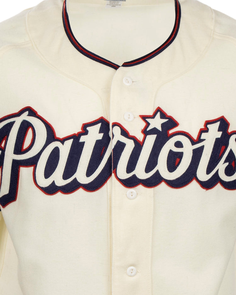 The EFF Dallas Baptist University Home Jersey is a cream Patriots baseball shirt with bold navy script, red outline, and a star over the i, inspired by the classic DBU jersey style.