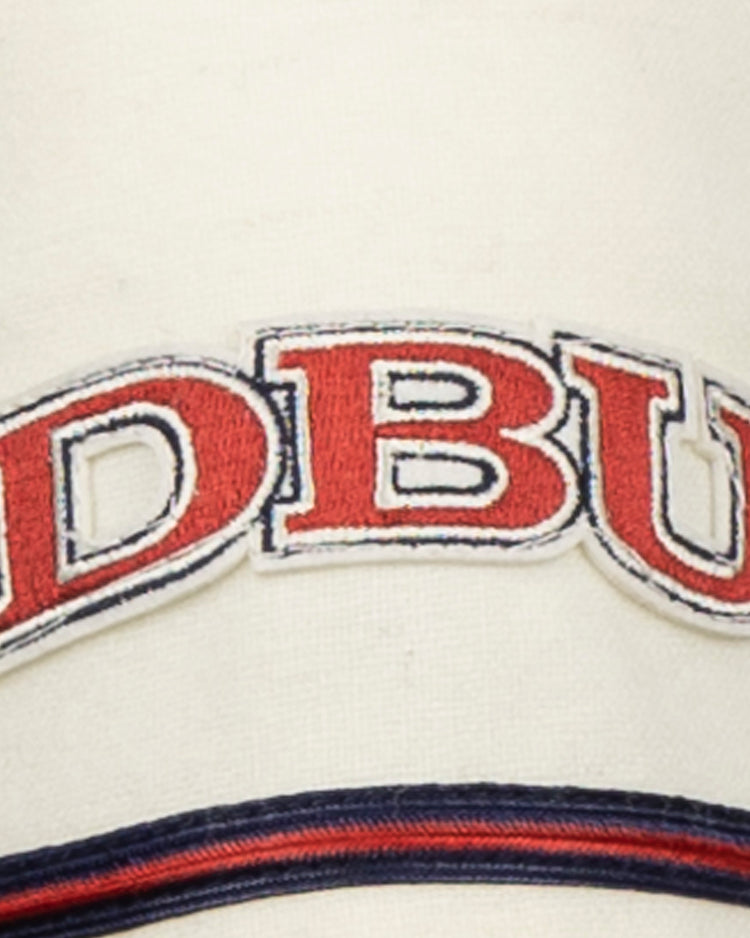 The EFF Dallas Baptist University Home Jersey features a cream base with bold red DBU letters outlined in blue, and navy and red stripes below, evoking a classic collegiate style.