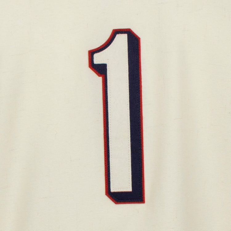 A large, bold white number 1 with dark blue and red outline stands centered on cream fabric, echoing the classic Dallas Baptist University Home Jersey by EFF.