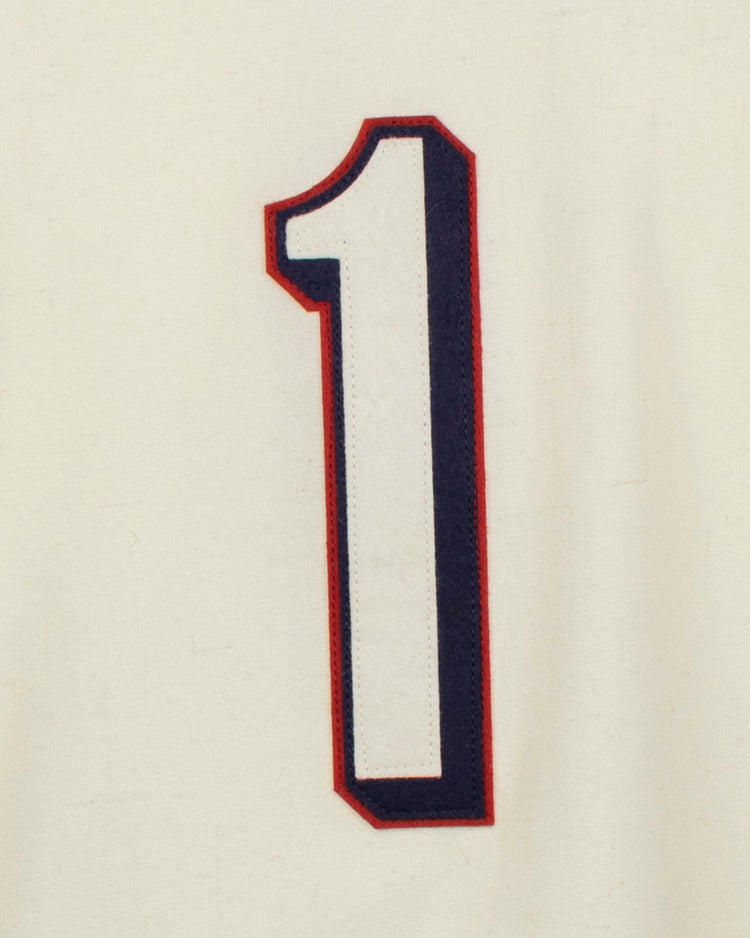 A large, bold white number 1 with dark blue and red outline stands centered on cream fabric, echoing the classic Dallas Baptist University Home Jersey by EFF.