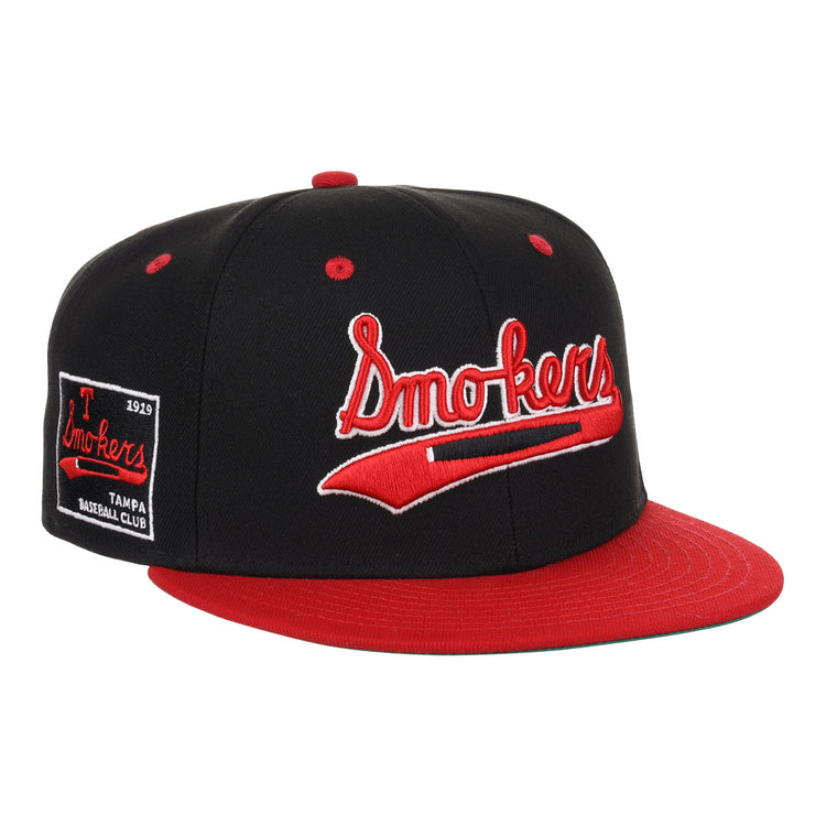 The EFF Tampa Smokers NLB Black and Red Fitted Ballcap features “Tampa Smokers” embroidered in red and white cursive on the front, with a side patch reading “Smokers Tampa Baseball Club 1919,” honoring the historic Florida International League.