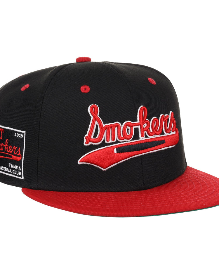 The EFF Tampa Smokers NLB Black and Red Fitted Ballcap features “Tampa Smokers” embroidered in red and white cursive on the front, with a side patch reading “Smokers Tampa Baseball Club 1919,” honoring the historic Florida International League.