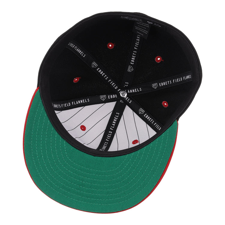 The image shows the underside of the EFF Tampa Smokers NLB Black and Red Fitted Ballcap, featuring a black crown, green brim, red stitching, and EFF branding on the inner band—a nod to classic Florida International League style.