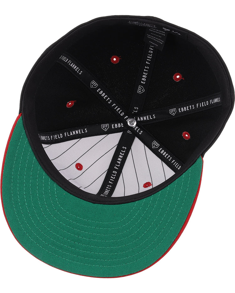 The image shows the underside of the EFF Tampa Smokers NLB Black and Red Fitted Ballcap, featuring a black crown, green brim, red stitching, and EFF branding on the inner band—a nod to classic Florida International League style.