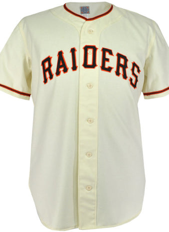 The EFF Pauls Valley Raiders 1954 Home Jersey is a cream baseball jersey with black and orange trim, featuring RAIDERS in bold black letters with orange outline across the chest, honoring the Sooner State League team.