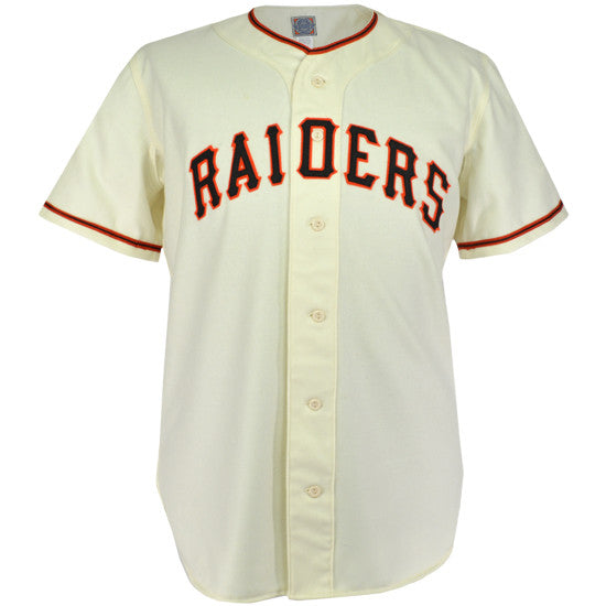 The EFF Pauls Valley Raiders 1954 Home Jersey is a cream baseball jersey with black and orange trim, featuring RAIDERS in bold black letters with orange outline across the chest, honoring the Sooner State League team.