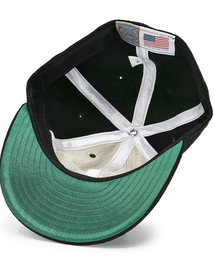 The EFF Baltimore Clippers 1962 Vintage Ballcap features a green underbill, white interior lining, and two labels—a classic American flag tag and a manufacturing label—evoking classic AHL style.
