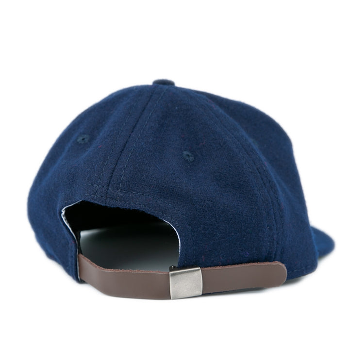 The EFF Bucknell University 1965 Vintage Ballcap is a navy wool cap, shown from the back, with a brown adjustable strap and silver clasp; inspired by a vintage design and proudly made in the USA.