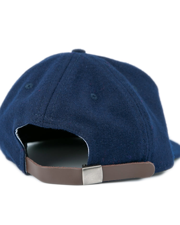 The EFF Bucknell University 1965 Vintage Ballcap is a navy wool cap, shown from the back, with a brown adjustable strap and silver clasp; inspired by a vintage design and proudly made in the USA.