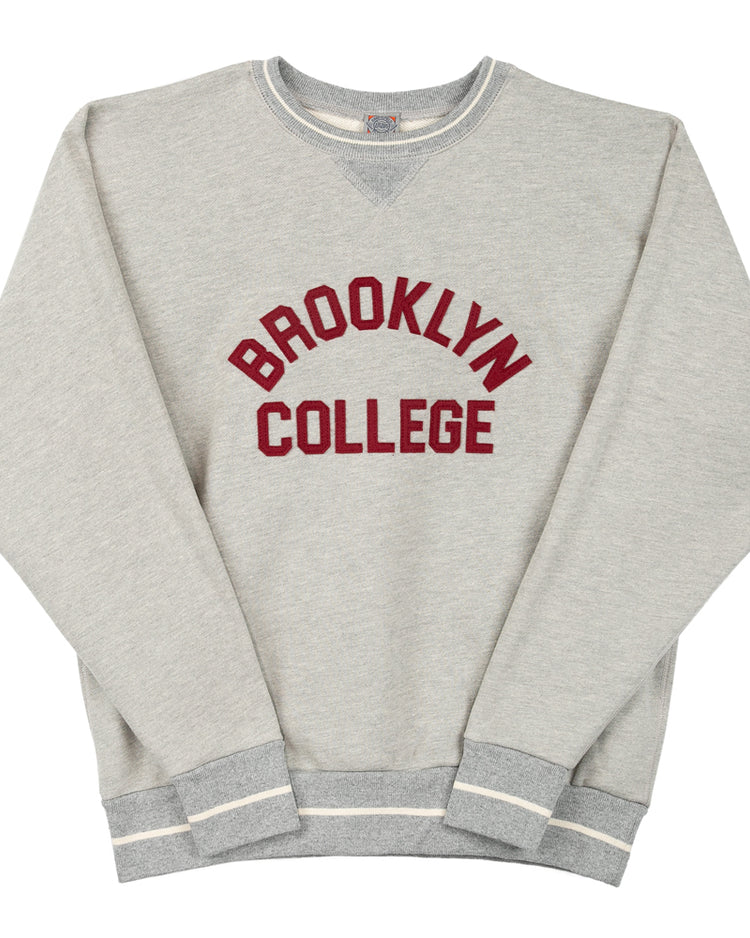 The EFF Brooklyn College Collegiate Vintage Crewneck Sweatshirt features light gray French terry fabric, bold maroon BROOKLYN COLLEGE print, and striped white/gray cuffs and hem for a timeless collegiate style.