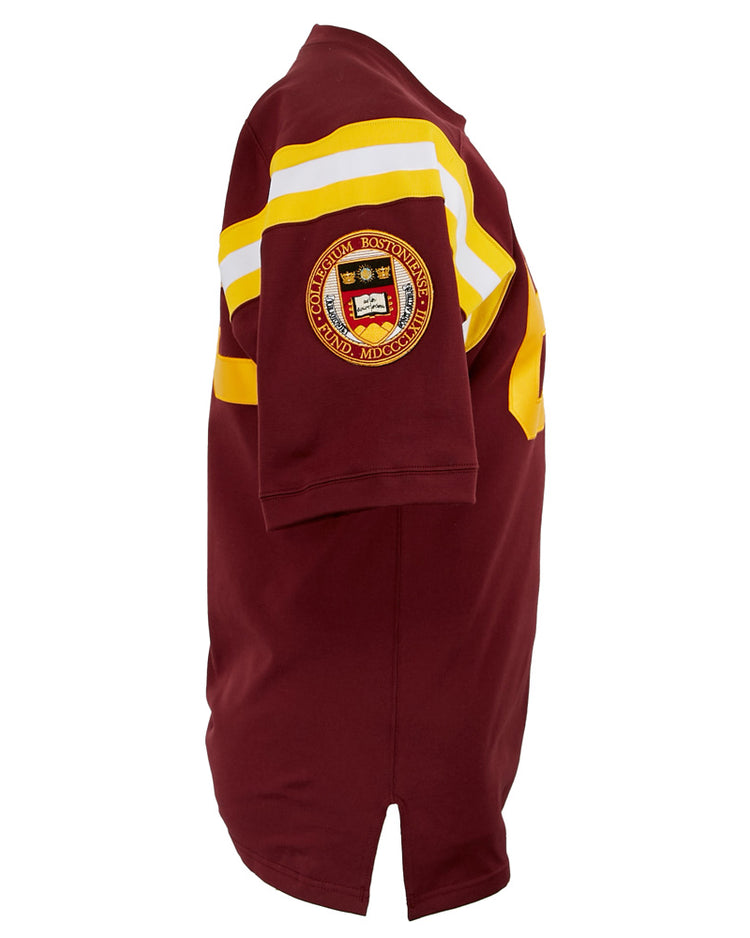 The EFF Boston College 1963 Durene Football Jersey features maroon short sleeves, yellow and white chest stripes, and an embroidered crest badge on the upper sleeve, faithfully reproducing the classic 1963 design.