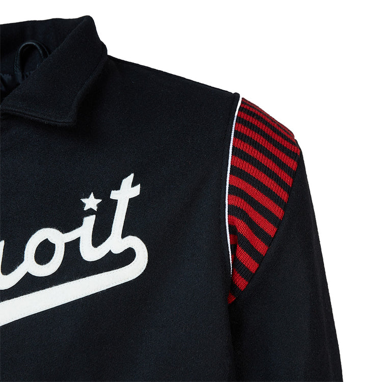Close-up of the EFF Detroit Stars 1950 Authentic Jacket, an exact reproduction featuring white script with a star dotting the i, red and black striped shoulder panel, collar, and white trim along the shoulder seam.