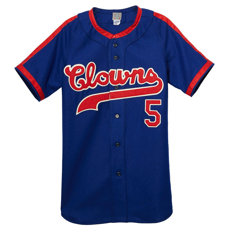 The EFF Indianapolis Clowns 1952 Road Jersey is a blue button-up with red trim, “Clowns” in white and red script across the chest, and number 5 on the lower right—honoring Henry Aaron’s time in the Negro Leagues.