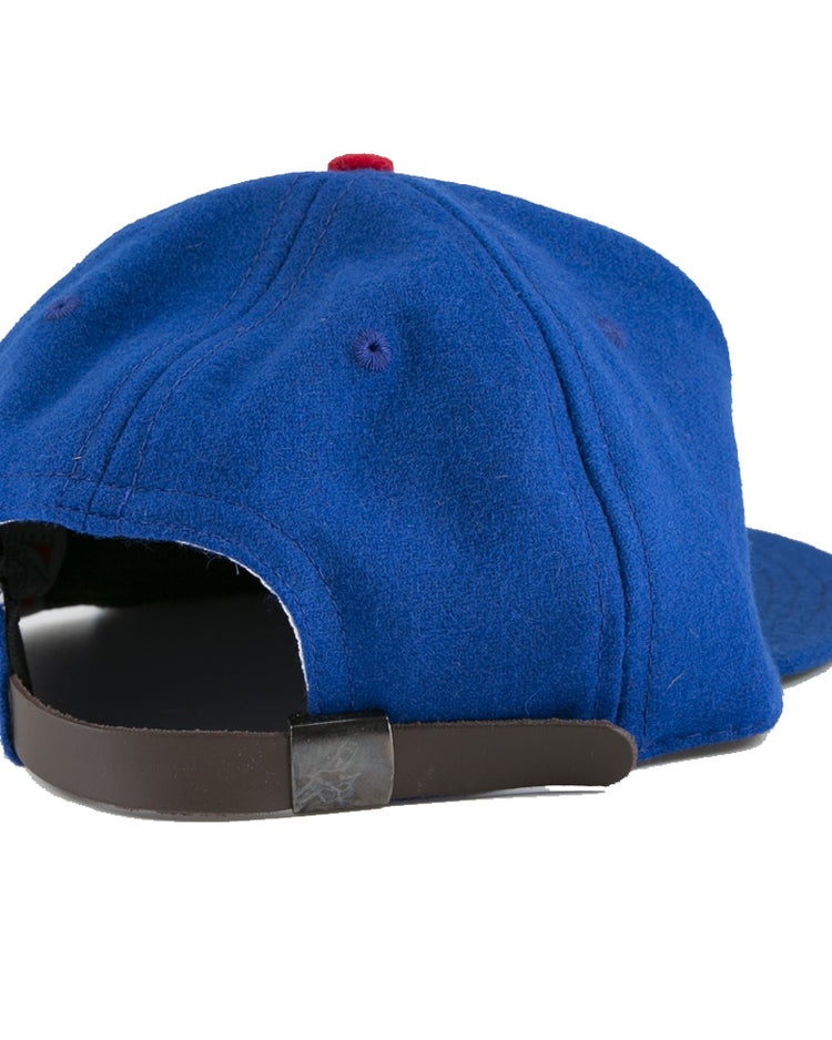 The EFF Jersey City Giants 1946 Vintage Ballcap is a blue wool cap with a red top button, visible stitching, and a brown adjustable strap with metal clasp, shown here from the back for classic vintage style.