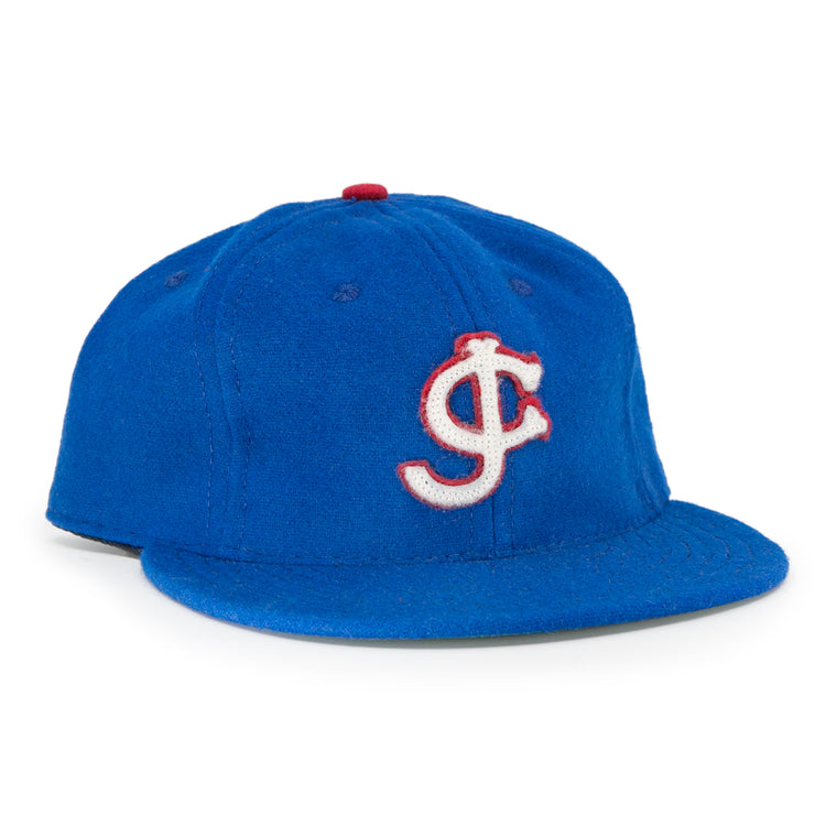 The EFF Jersey City Giants 1946 Vintage Ballcap is blue wool, featuring a white and red outlined interlocking J and C logo on the front and a red top button—faithful to the classic design.