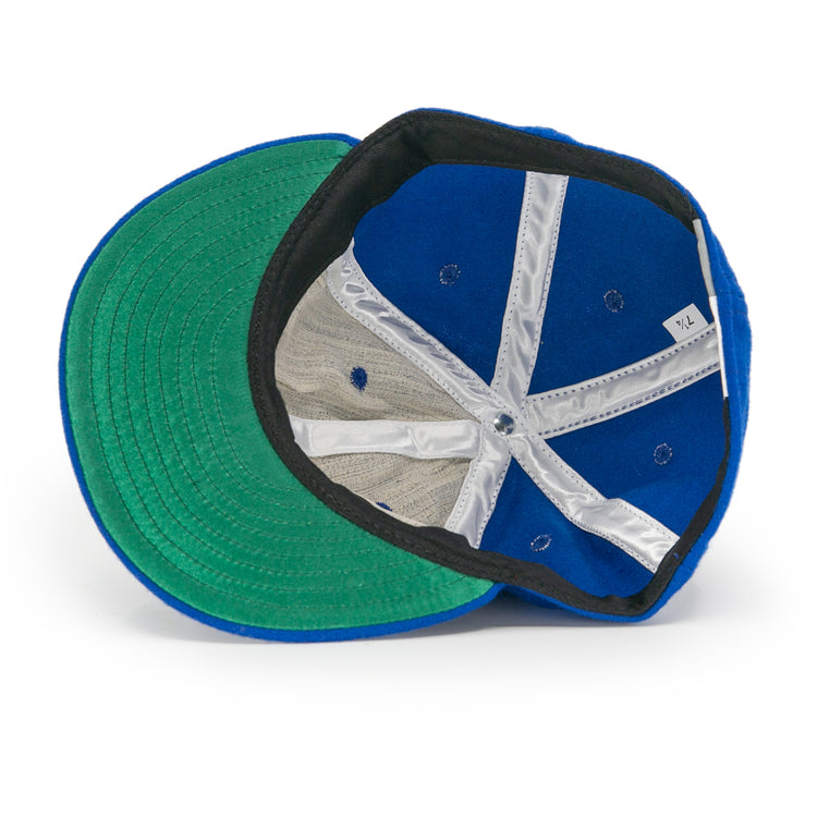 A look inside the EFF Jersey City Giants 1946 Vintage Ballcap reveals a blue cap with green brim, black inner band, white mesh lining, X-pattern white fabric strips, and a visible size tag.