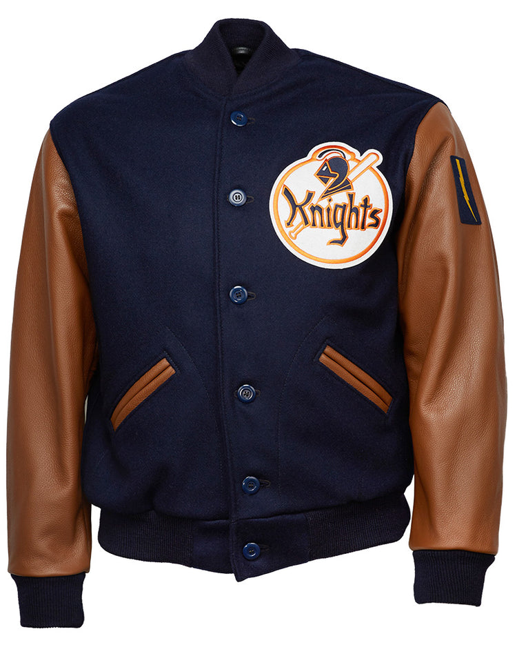 The EFF New York Knights 1939 Authentic Jacket features navy melton wool, brown leather sleeves, front pockets, a large Knights patch on the left chest, button-up front, and ribbed cuffs and waistband for a classic varsity look.