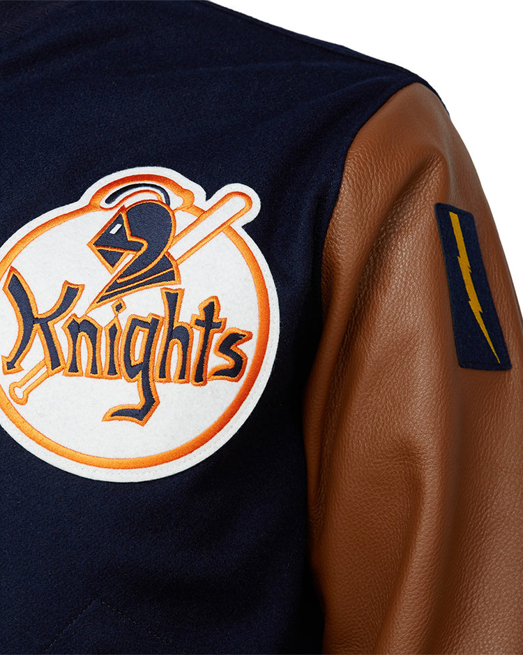 A close-up of the EFF New York Knights 1939 Authentic Jacket, crafted from melton wool with brown leather sleeves, featuring a large chest patch of a knight’s helmet and bat, plus a blue patch with a yellow lightning bolt on the sleeve.