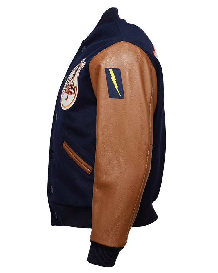 The EFF New York Knights 1939 Authentic Jacket is a navy melton wool varsity jacket with tan leather sleeves, a yellow lightning bolt patch on the upper arm, and a circular chest logo, shown from a side angle.