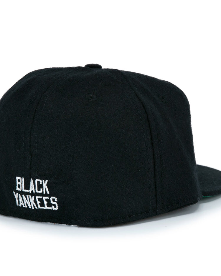 The EFF New York Black Yankees Vintage Inspired Ballcap is a classic black wool hat, seen from the back with BLACK YANKEES embroidered in white near the bottom edge—true vintage baseball style.