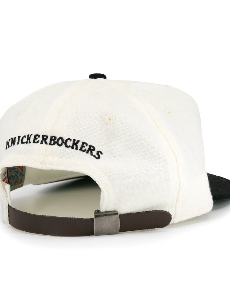 The EFF New York Knickerbockers Vintage Inspired Ballcap features a white crown, black brim, “KNICKERBOCKERS” embroidered in black, and an adjustable brown strap for a classic look.