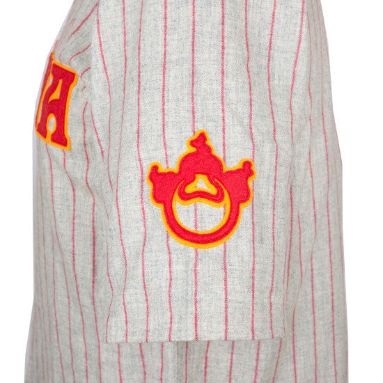 A close-up side view of the EFF Nagoya Club 1938 Road Jersey shows its authentic gray design with thin red stripes, a red and yellow embroidered sleeve patch, and part of a yellow-red letter A on the chest.