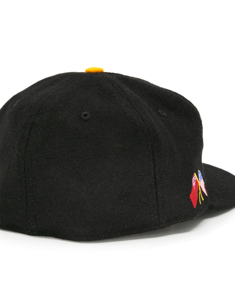 The EFF Pittsburgh Hornets 1953 Vintage Ballcap is a black wool hat with a flat brim, yellow top button, and a small colorful embroidered design on the back, inspired by vintage hockey style.
