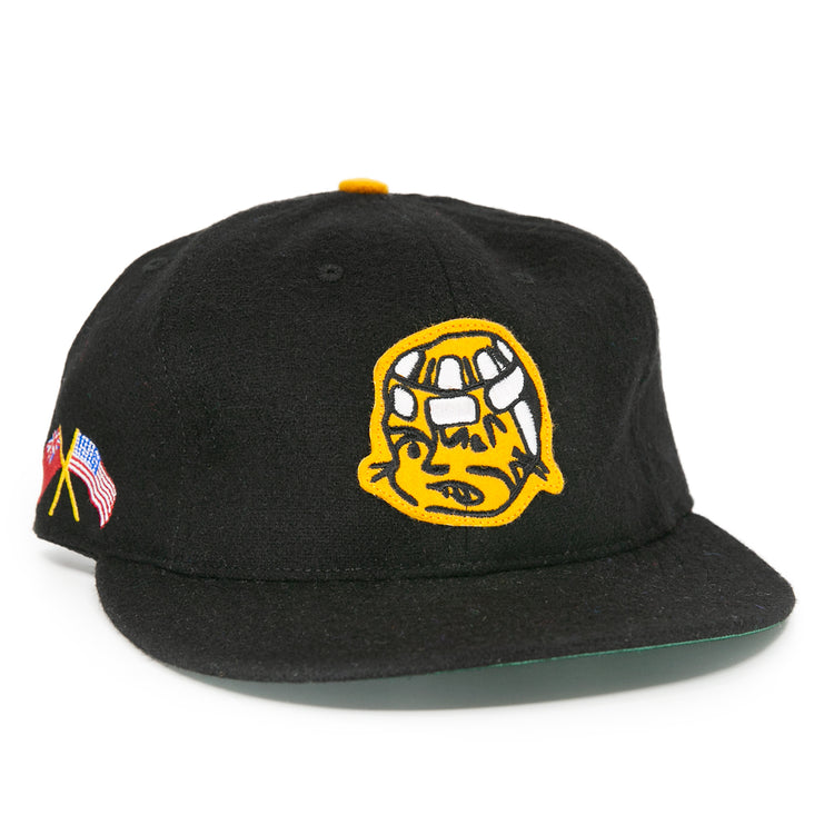The EFF Pittsburgh Hornets 1953 Vintage Ballcap is a black wool hat featuring a yellow embroidered cartoon face on the front and American and Japanese flags on the side, inspired by classic Hornets style.