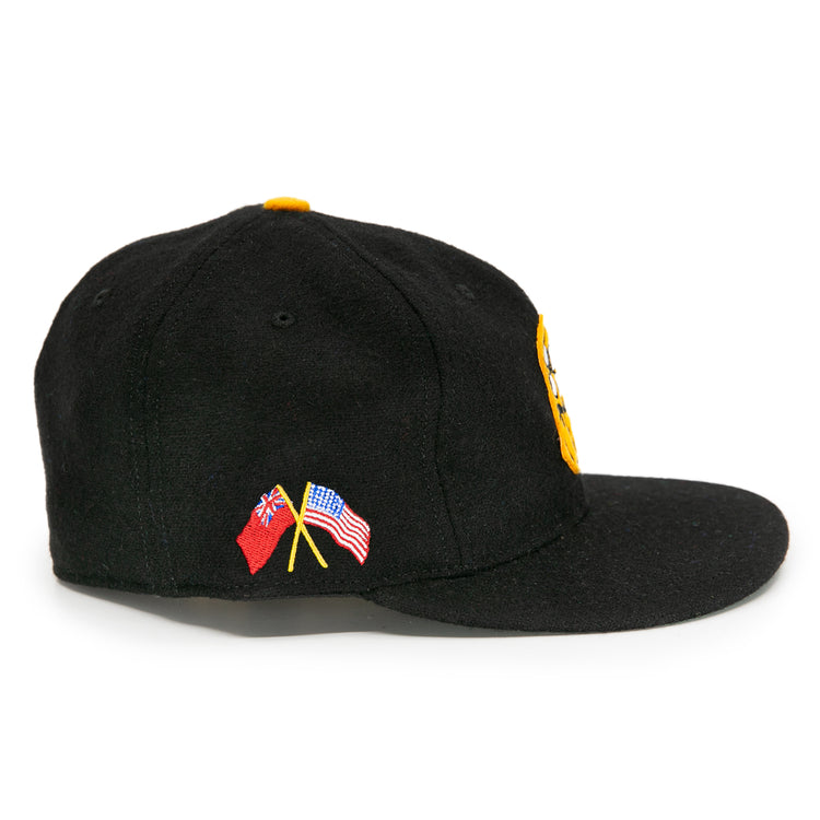 The EFF Pittsburgh Hornets 1953 Vintage Ballcap is a black wool cap with yellow front embroidery and small crossed American and British flags on the left, capturing classic Hornets spirit.
