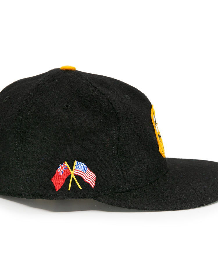 The EFF Pittsburgh Hornets 1953 Vintage Ballcap is a black wool cap with yellow front embroidery and small crossed American and British flags on the left, capturing classic Hornets spirit.
