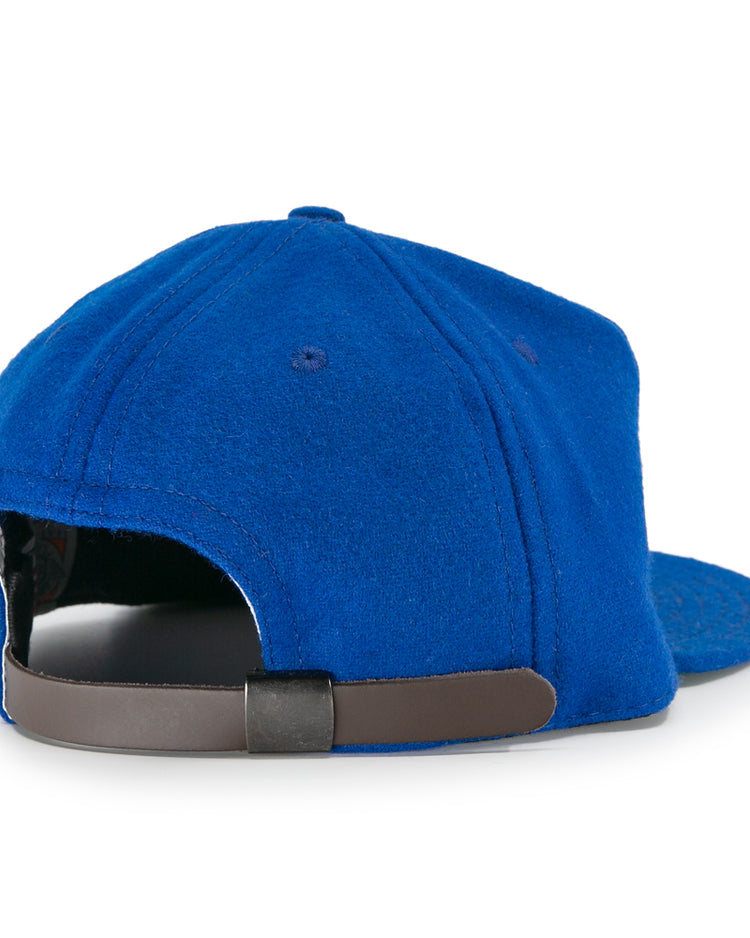 The EFF Puerto Rico Marlins 1961 Vintage Ballcap is a blue wool hat with a curved brim and an adjustable leather strap, styled after classic baseball caps and inspired by the original Marlins design.
