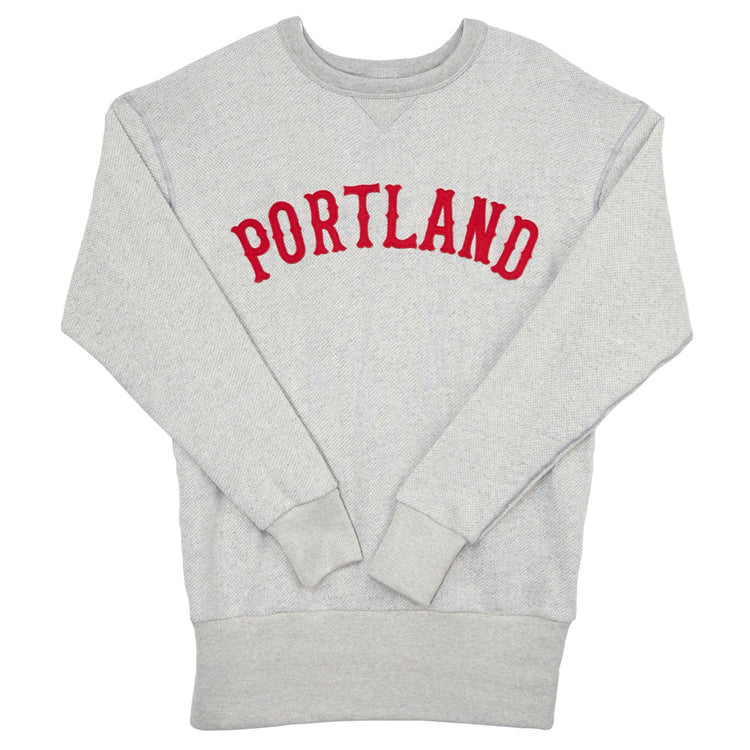 The EFF Portland Beavers Crewneck Sweatshirt is a light gray French terry vintage-cut top with PORTLAND in bold red letters across the chest, plus ribbed cuffs and hem for comfort.
