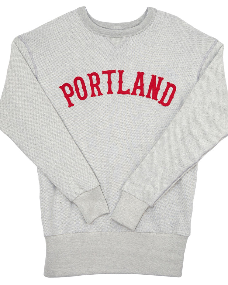 The EFF Portland Beavers Crewneck Sweatshirt is a light gray French terry vintage-cut top with PORTLAND in bold red letters across the chest, plus ribbed cuffs and hem for comfort.